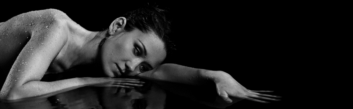 Black and white photo of  woman in lying in water